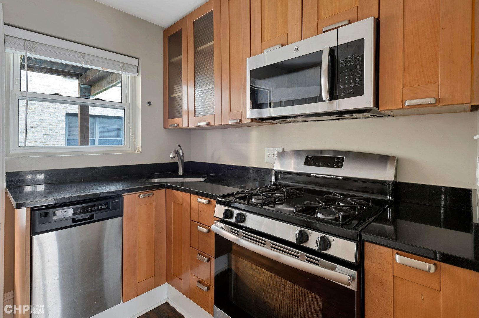 7425 North Sheridan Road, Unit 1E Chicago, IL 60626 - Photo 7 of 31 a kitchen with stainless steel appliances granite countertop a stove and a microwave