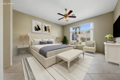 a bedroom with a bed a couch and a flat screen tv