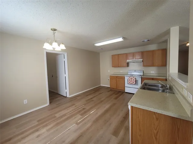 a kitchen with stainless steel appliances a stove top oven a sink and a refrigerator