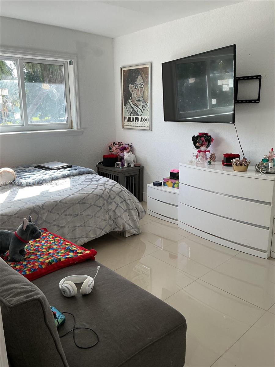 9700 Southwest 189th Street Cutler Bay, FL 33157 - Photo 12 of 21 a bedroom with a bed and a flat tv screen on the dresser