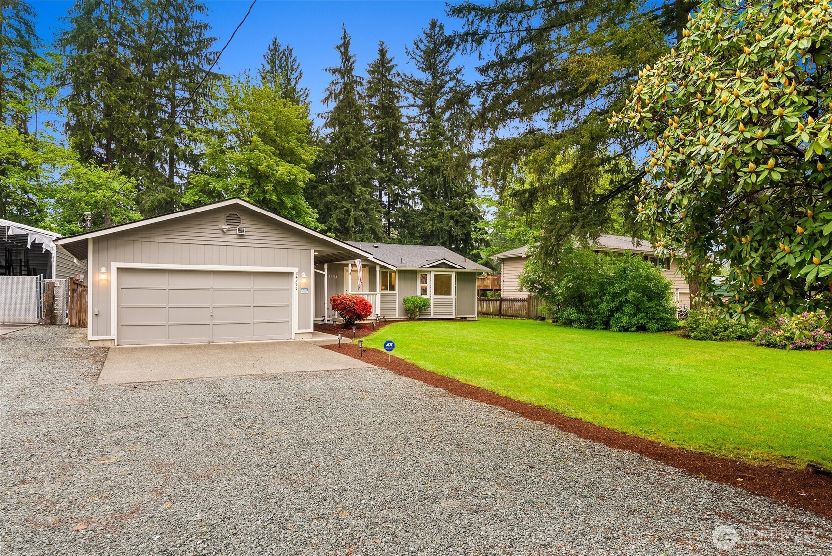 a view of a house with a yard and large trees