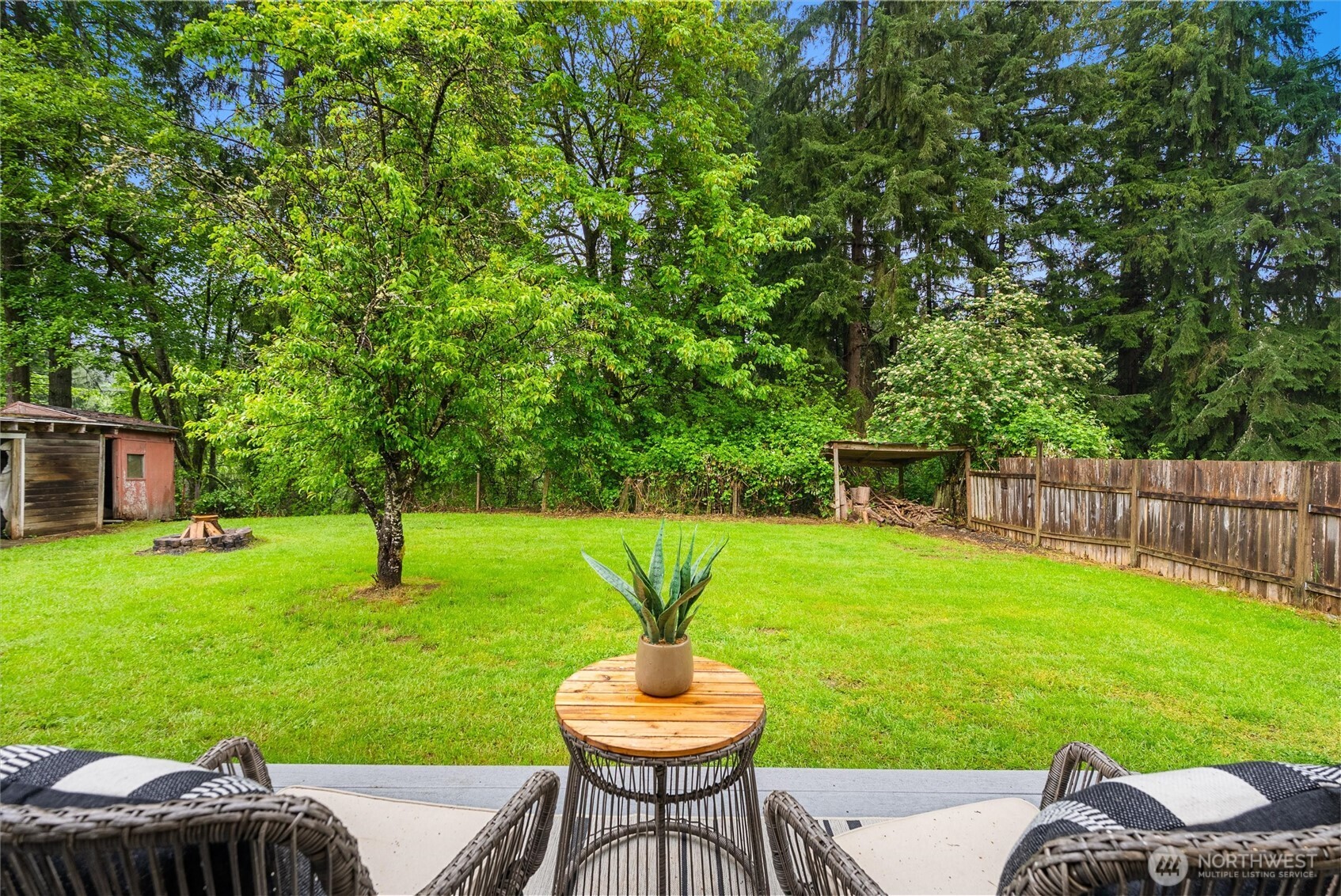 24711 Florence Acres Road Monroe, WA 98272 - Photo 26 of 33 a view of a backyard with table and chairs potted plants and a tree