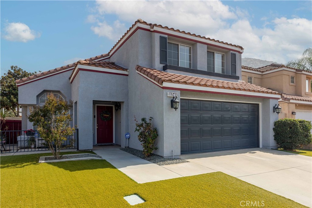 11541 Plane Tree Road Fontana, CA 92337 - Photo 2 of 33 a house with a large window and potted plants in front of door