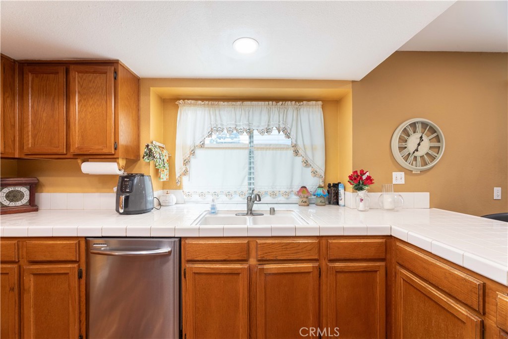 11541 Plane Tree Road Fontana, CA 92337 - Photo 23 of 33 a kitchen with stainless steel appliances granite countertop a sink window and cabinets