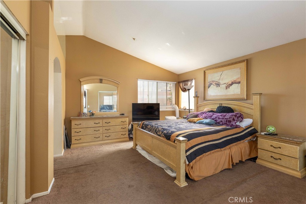 11541 Plane Tree Road Fontana, CA 92337 - Photo 25 of 33 a spacious bedroom with a bed and wooden floor