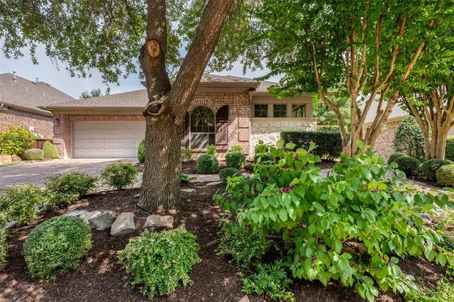 a front view of a house with a tree
