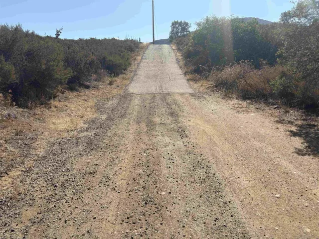 a view of a dry yard with mountain view