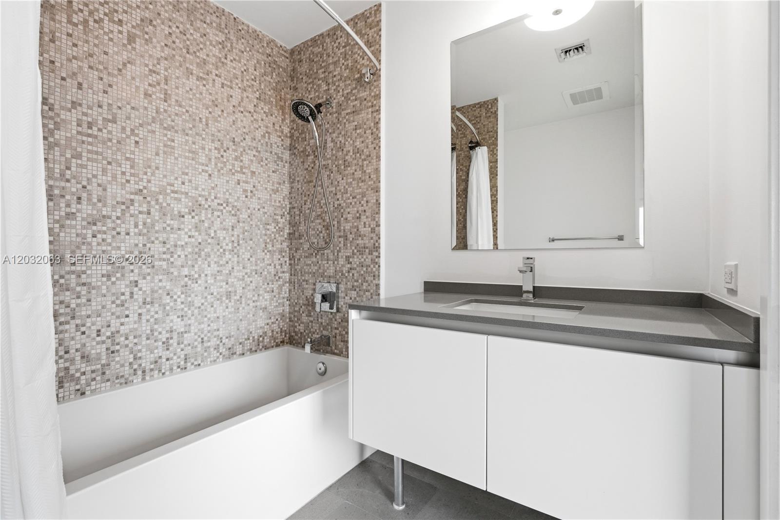 88 Southwest 7th Street, Unit 2302 Miami, FL 33130 - Photo 21 of 26 a bathroom with a granite countertop sink a toilet and bathtub