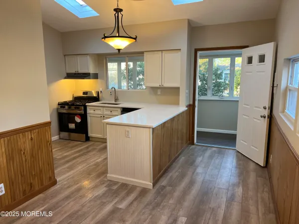a kitchen with a stove a refrigerator and a fireplace with wooden floor