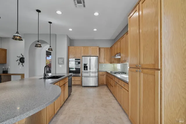 a kitchen with granite countertop a refrigerator and cabinets