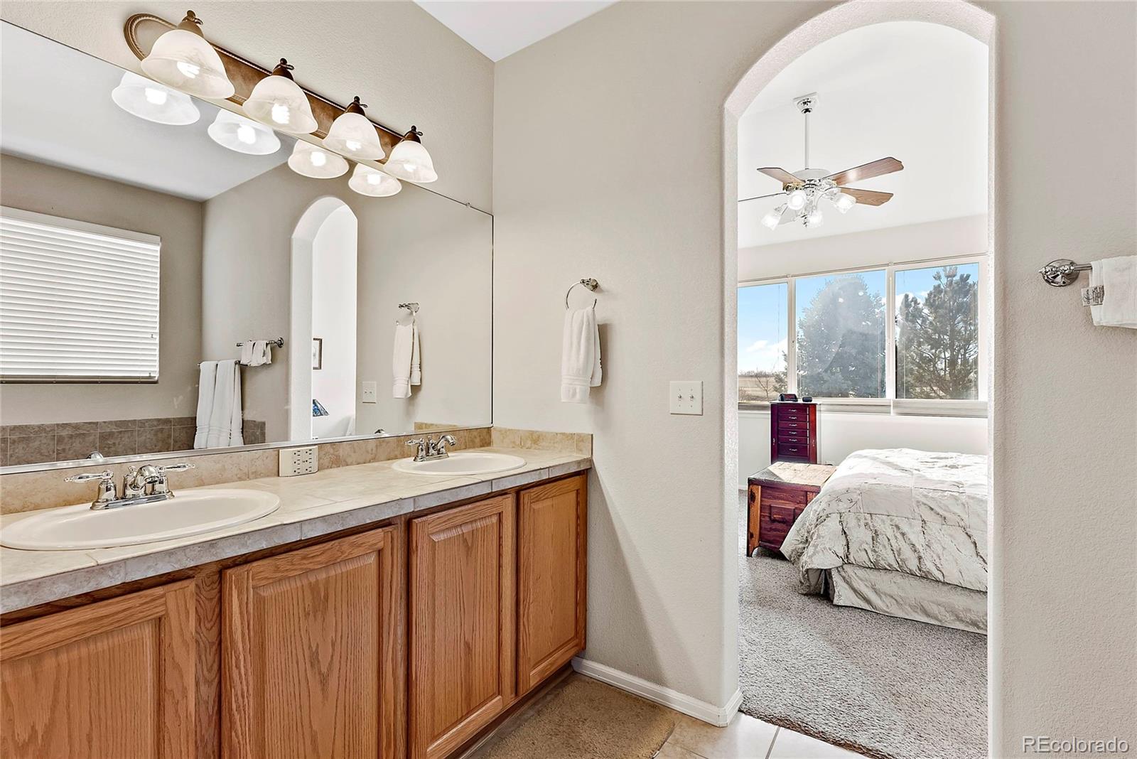 8006 Raspberry Drive Frederick, CO 80504 - Photo 15 of 27 a en suite bathroom with a double vanity sink and a mirror