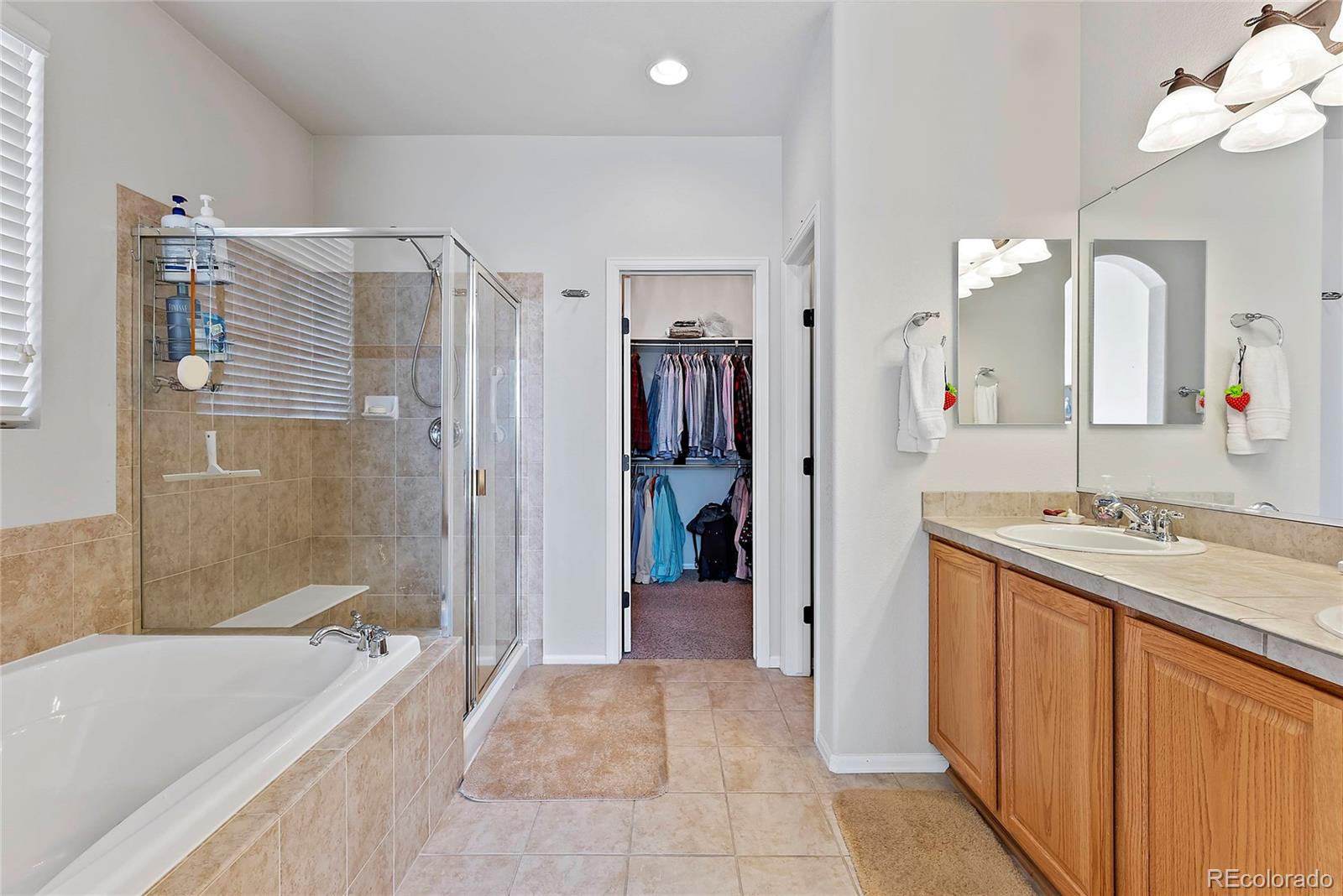 8006 Raspberry Drive Frederick, CO 80504 - Photo 17 of 27 a bathroom with a granite countertop sink a mirror a bathtub and shower