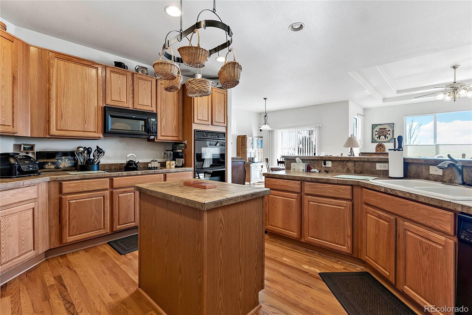 8006 Raspberry Drive Frederick, CO 80504 - Photo 9 of 27 a kitchen with a chandelier stainless steel appliances cabinets and a counter top space