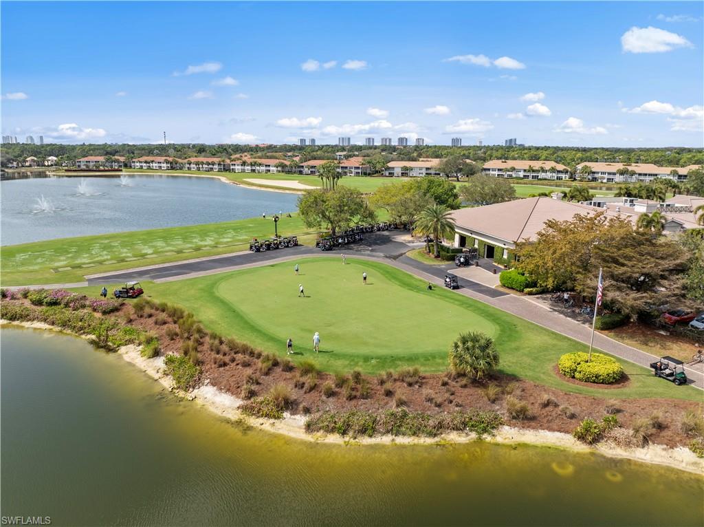 9331 Spring Run Boulevard, Unit 3005 Estero, FL 34135 - Photo 42 of 48 Lush green golf course with adjacent water features, a clubhouse, and mature landscaping