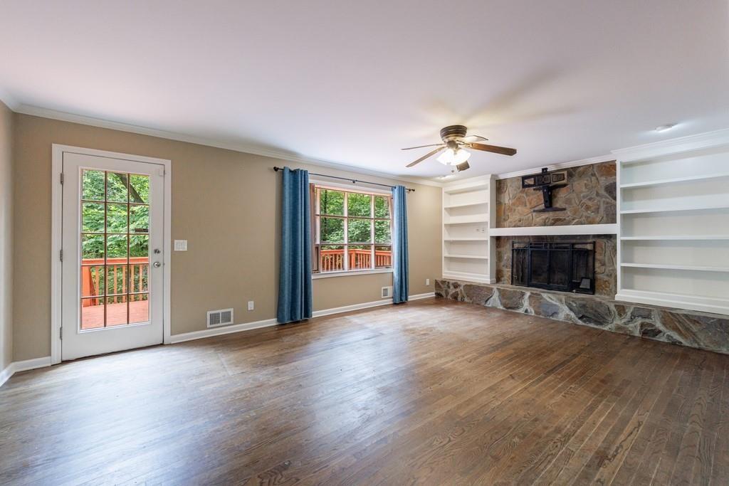 10565 Shallowford Road Roswell, GA 30075 - Photo 12 of 18 a view of an empty room with wooden floor fireplace and a window