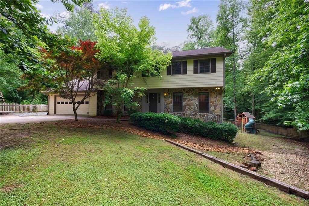 10565 Shallowford Road Roswell, GA 30075 - Photo 4 of 18 a view of a house with a yard and a garden