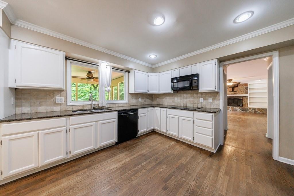 10565 Shallowford Road Roswell, GA 30075 - Photo 7 of 18 a kitchen with stainless steel appliances granite countertop wooden cabinets a sink and dishwasher a stove with wooden floors