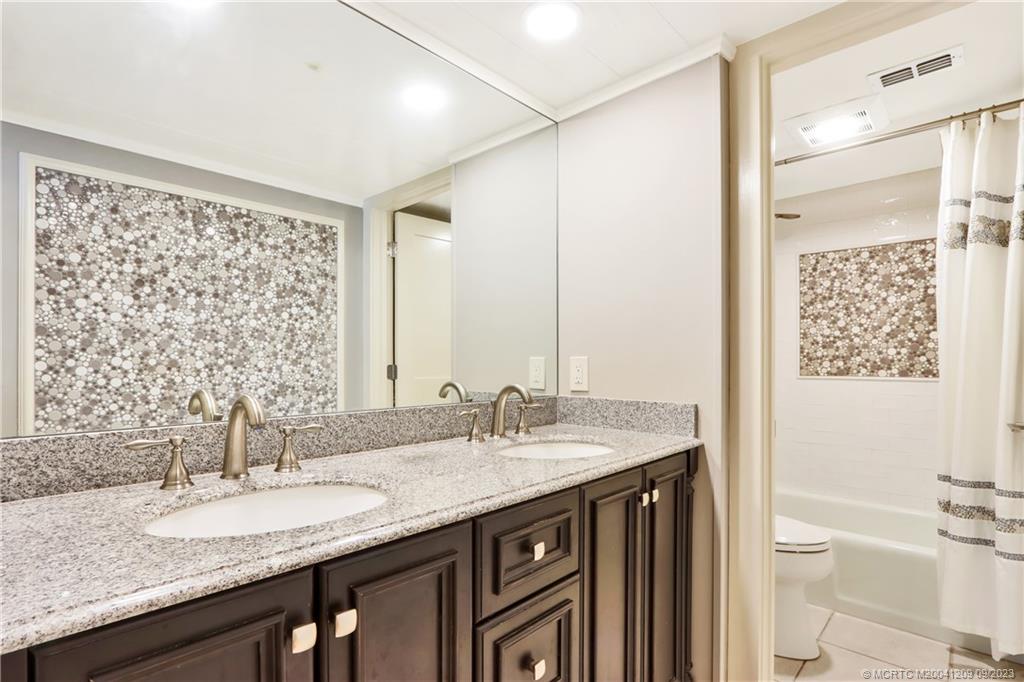 1862 Southwest Palm City Road, Unit 202 Stuart, FL 34994 - Photo 12 of 15 a bathroom with a granite countertop sink and a mirror