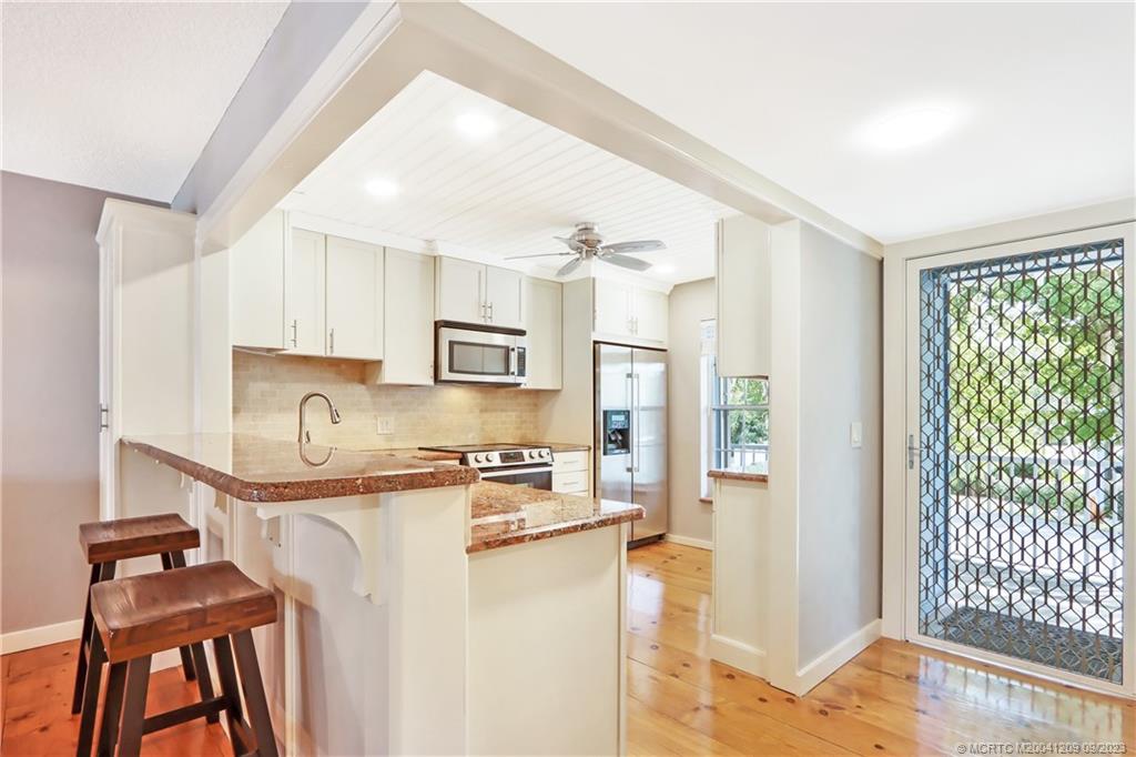 1862 Southwest Palm City Road, Unit 202 Stuart, FL 34994 - Photo 6 of 15 a kitchen with stainless steel appliances granite countertop a stove a refrigerator and a sink
