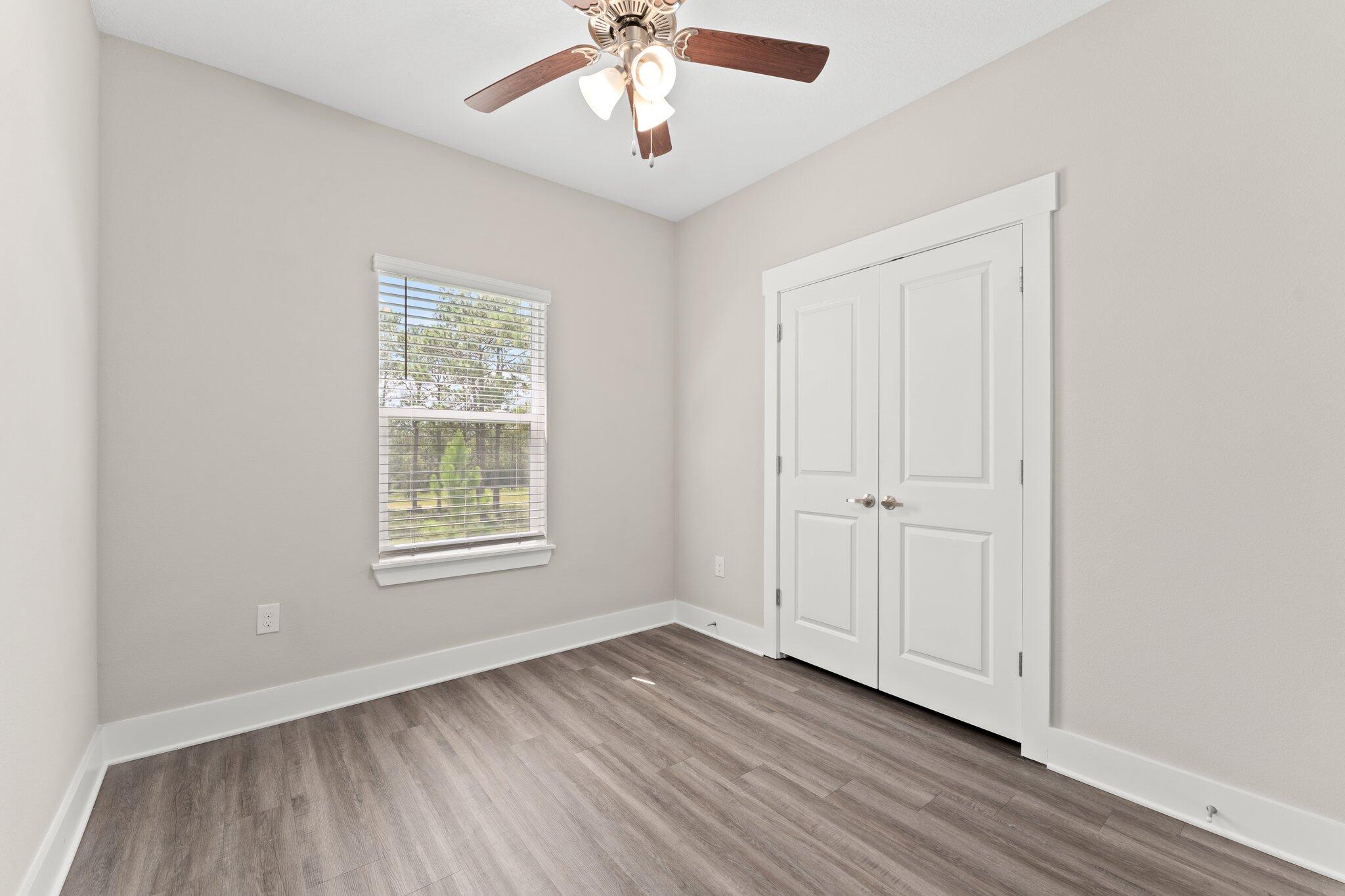 352 North Sand Palm Road, Unit VISTA Freeport, FL 32439 - Photo 24 of 29 an empty room with wooden floor chandelier fan and windows