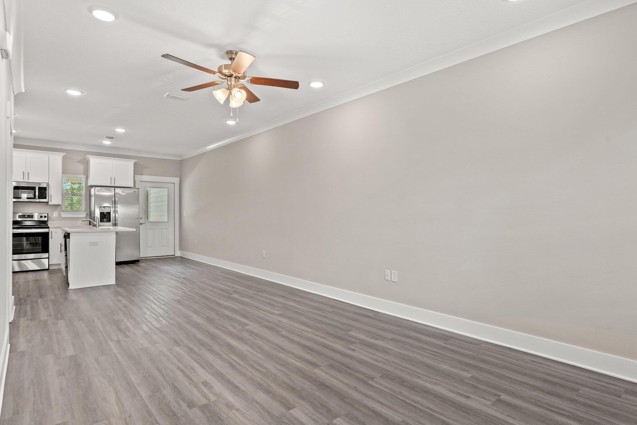 352 North Sand Palm Road, Unit VISTA Freeport, FL 32439 - Photo 4 of 29 a view of a kitchen with a sink a ceiling fan and wooden floor