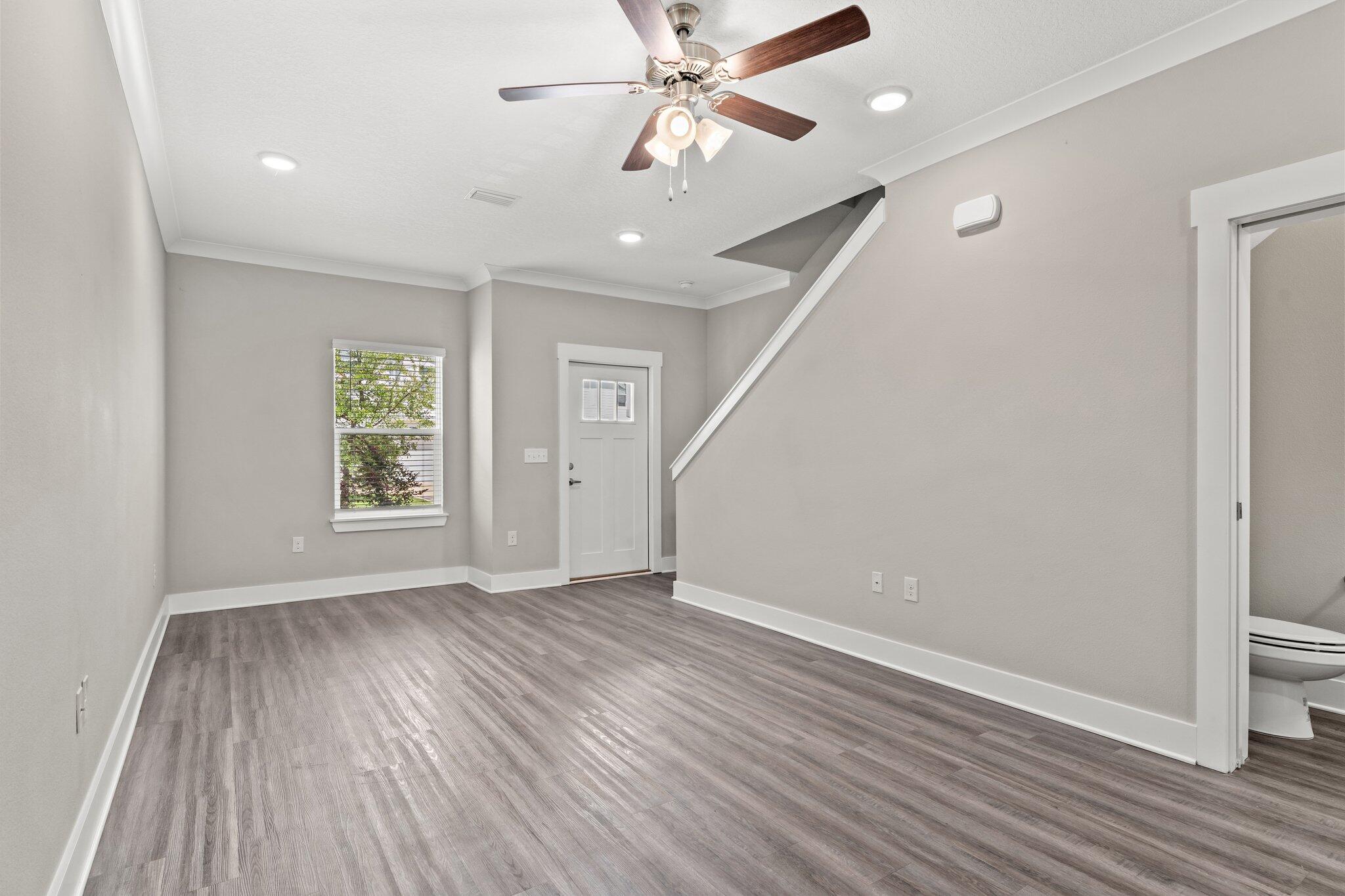 352 North Sand Palm Road, Unit VISTA Freeport, FL 32439 - Photo 6 of 29 an empty room with wooden floor chandelier fan and windows