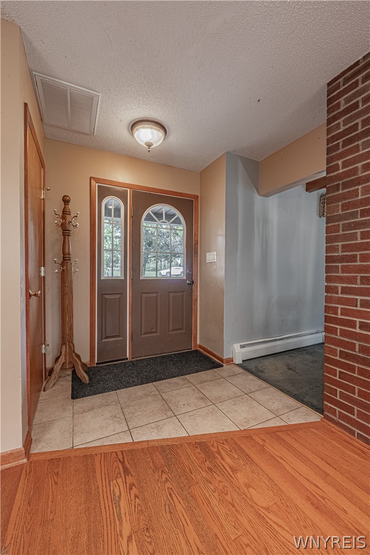 A welcoming entryway transitions seamlessly from durable tile to warm hardwood​​‌​​​​‌​​‌‌​‌‌​​‌​​​​‌​​​‌‌​‌‌‌ flooring.