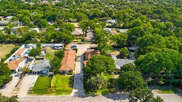 an aerial view of residential houses with outdoor space and trees