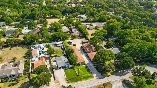 an aerial view of residential houses with outdoor space and trees
