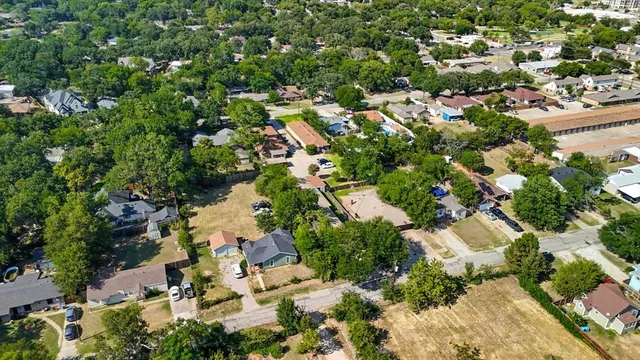 an aerial view of residential houses with outdoor space and trees all around