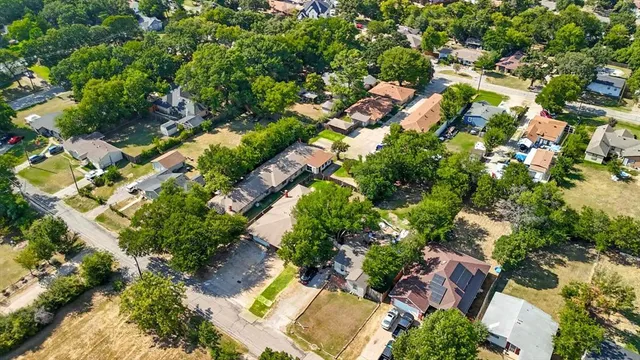 an aerial view of residential houses with outdoor space and trees