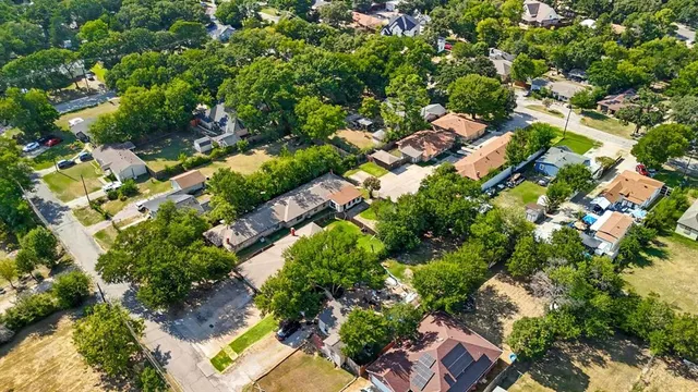 an aerial view of residential houses with outdoor space and trees
