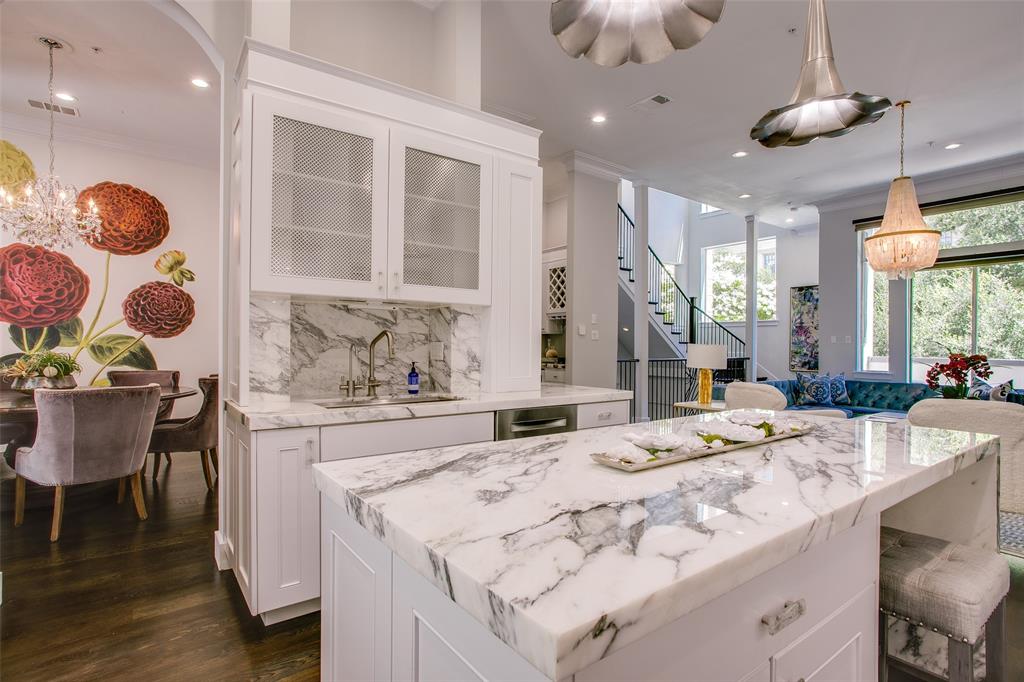 2211 Worthington Street Dallas, TX 75204 - Photo 16 of 36 a large kitchen with kitchen island granite countertop a stove a sink a dining table and chairs with wooden floor
