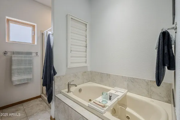a bathroom with a tub a sink and a window