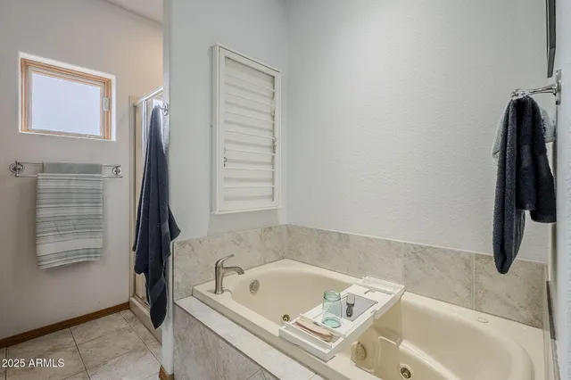 a bathroom with a tub a sink and a window