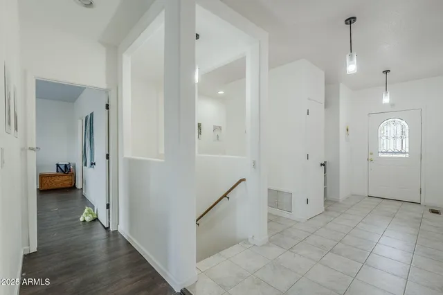 a view of a hallway with wooden floor and furniture
