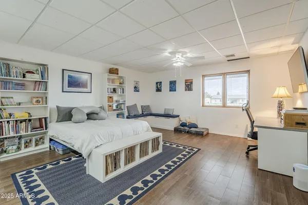 a spacious bedroom with a bed a table and a large window