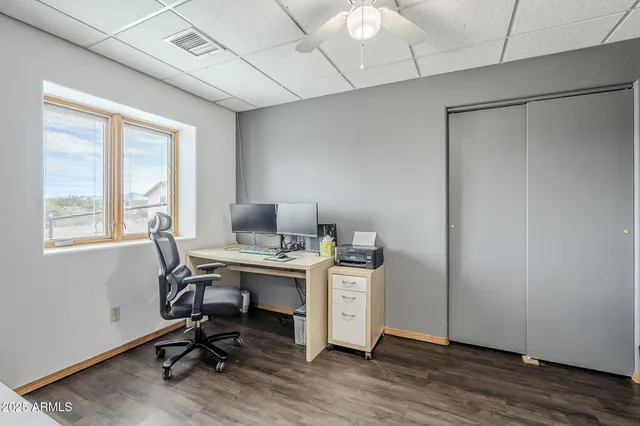 a view of a workspace with furniture and a window