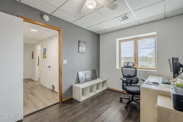 a view of a workspace with furniture and a window