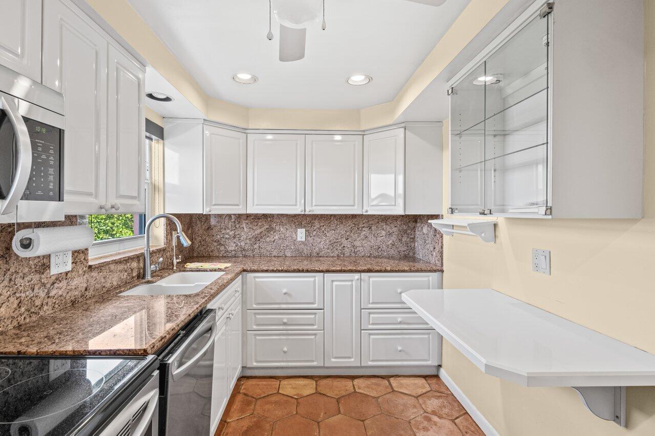 1040 Banyan Road, Unit 501C Boca Raton, FL 33432 - Photo 18 of 47 a kitchen with granite countertop a sink and a stove
