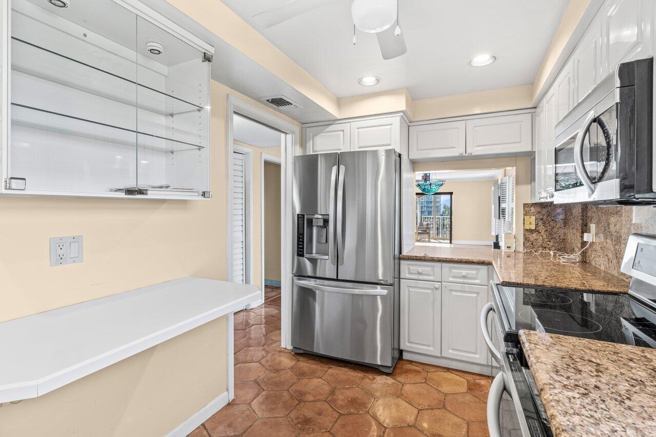 1040 Banyan Road, Unit 501C Boca Raton, FL 33432 - Photo 19 of 47 a kitchen with granite countertop a refrigerator and a stove top oven