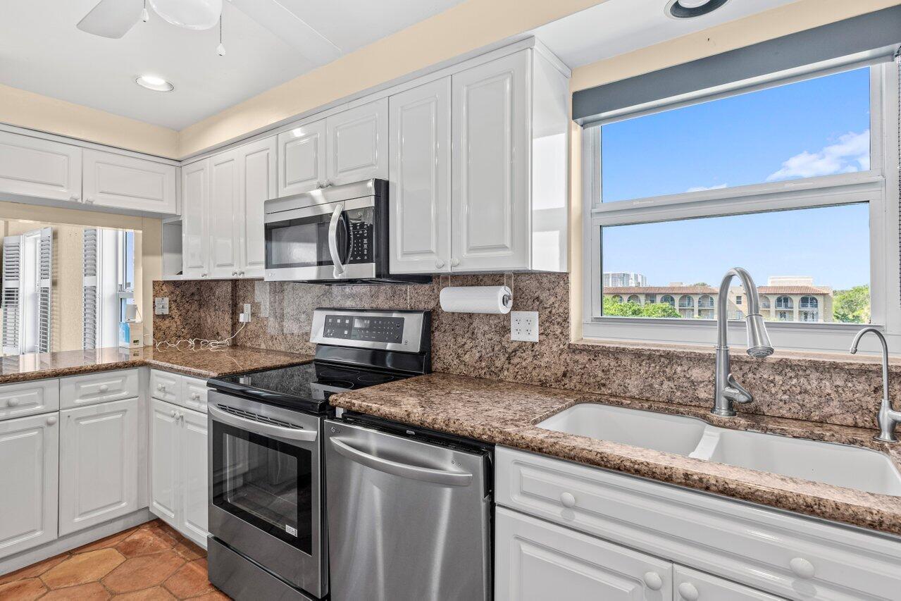 1040 Banyan Road, Unit 501C Boca Raton, FL 33432 - Photo 20 of 47 a kitchen with stainless steel appliances granite countertop a sink stove and microwave
