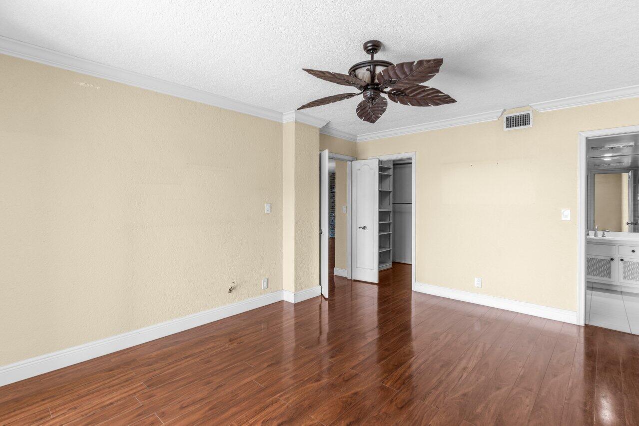 1040 Banyan Road, Unit 501C Boca Raton, FL 33432 - Photo 23 of 47 a view of an empty room with wooden floor and a ceiling fan