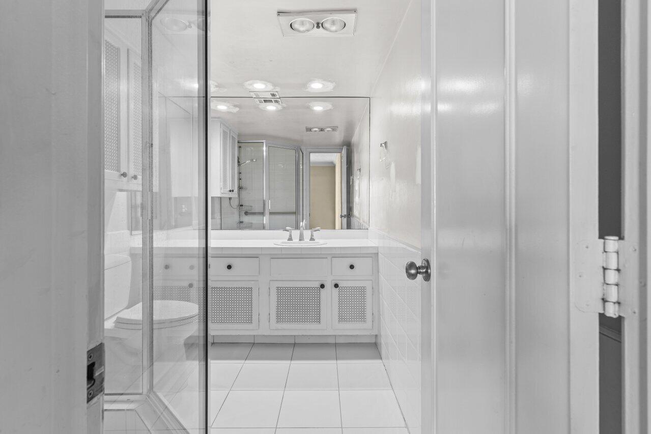 1040 Banyan Road, Unit 501C Boca Raton, FL 33432 - Photo 25 of 47 a bathroom with a shower sink and mirror