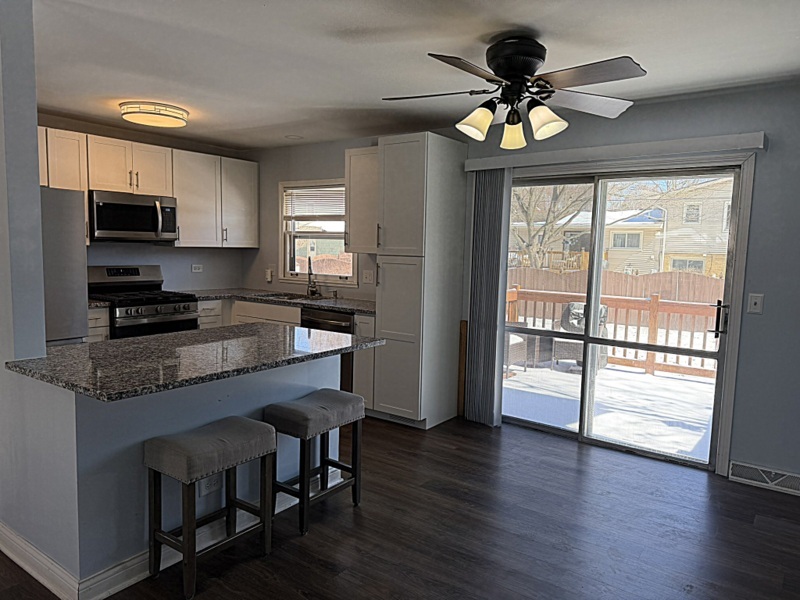 620 South 9th Avenue St. Charles, IL 60174 - Photo 7 of 30 a kitchen with stainless steel appliances granite countertop a stove top oven a refrigerator a dining table and chairs with wooden floor
