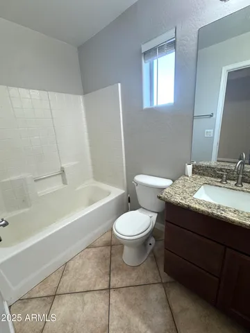 a bathroom with a granite countertop toilet a sink and bathtub