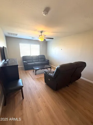 a living room with furniture and a wooden floor