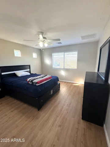 a spacious bedroom with a bed and wooden floor