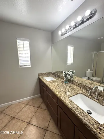 a bathroom with a granite countertop sink a vanity and a mirror