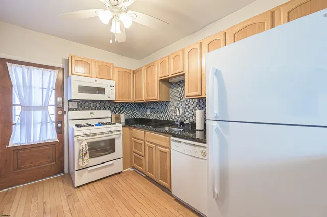 a kitchen with a refrigerator sink and cabinets